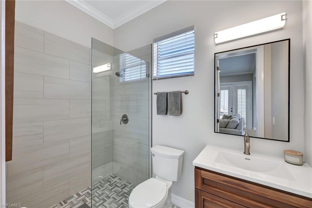 4624 Pond Apple Drive North Naples, FL 34119 - Photo 20 of 46 a bathroom with a sink toilet a mirror and shower