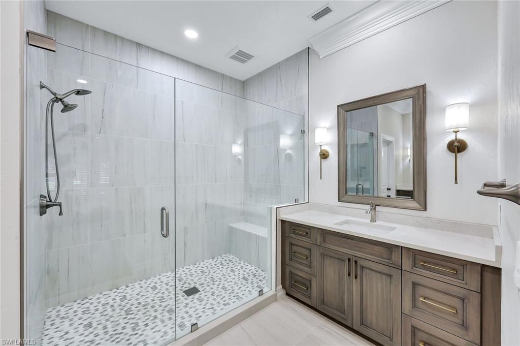 4624 Pond Apple Drive North Naples, FL 34119 - Photo 22 of 46 a bathroom with a shower sink and mirror