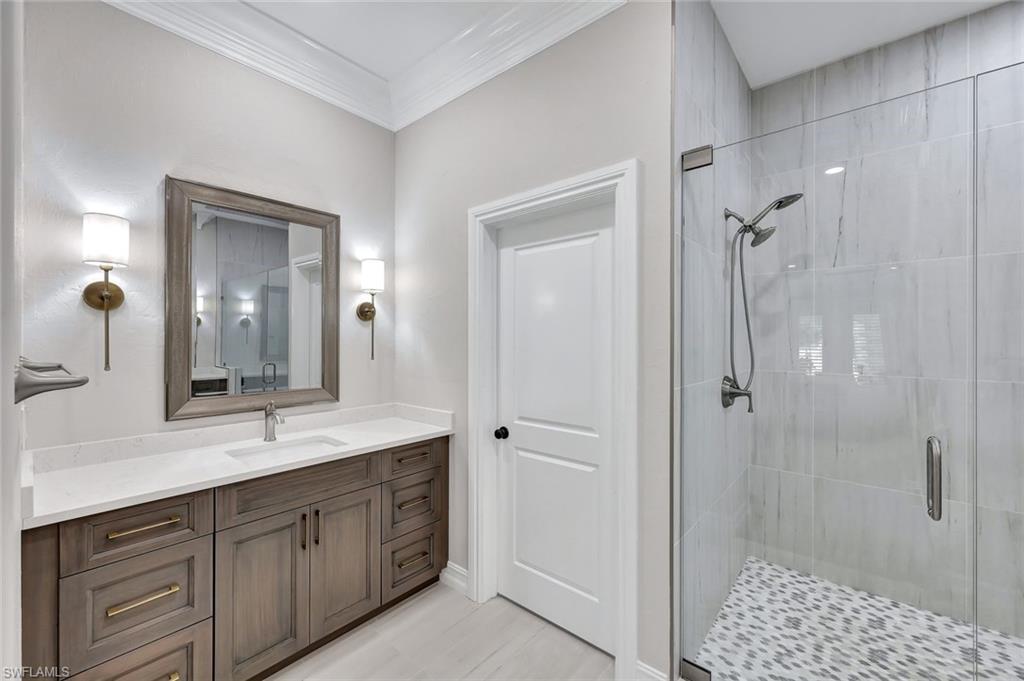 4624 Pond Apple Drive North Naples, FL 34119 - Photo 23 of 46 a spacious bathroom with a shower sink double and mirror
