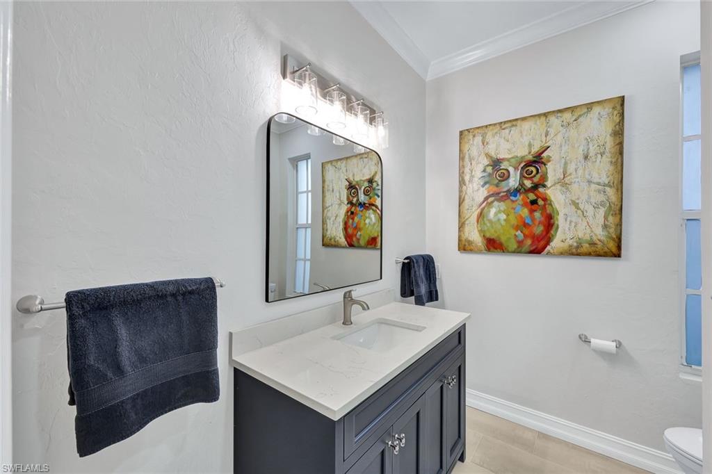 4624 Pond Apple Drive North Naples, FL 34119 - Photo 26 of 46 a bathroom with a sink and a painting on the wall