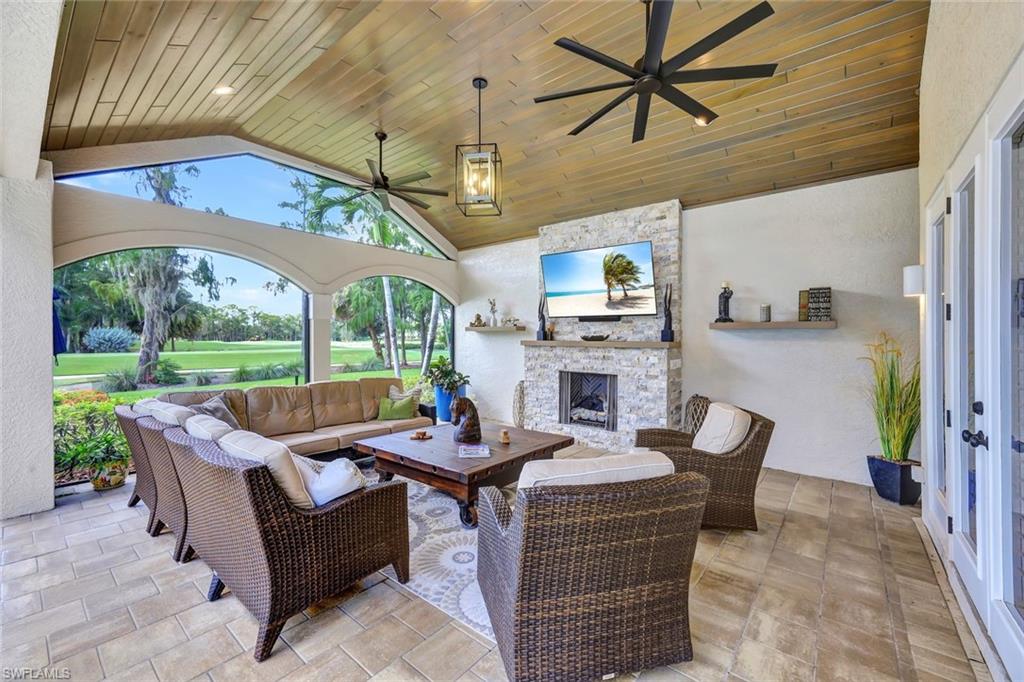 4624 Pond Apple Drive North Naples, FL 34119 - Photo 32 of 46 a living room with furniture a fireplace and a table
