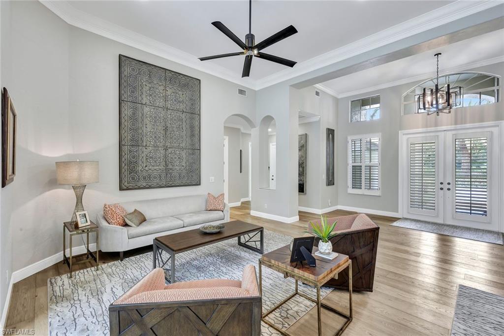 4624 Pond Apple Drive North Naples, FL 34119 - Photo 6 of 46 a living room with furniture and a chandelier