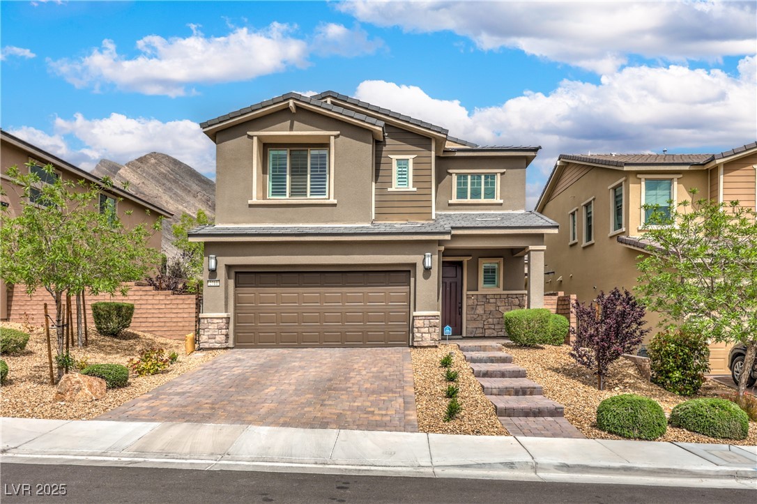 2711 Evolutionary Lane Las Vegas, NV 89138 - Photo 2 of 37 View of front of home featuring stone siding, stucco siding, and a garage