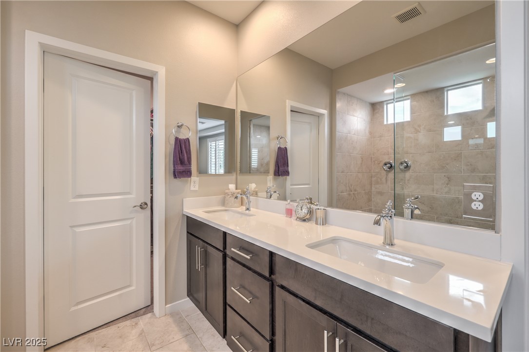 2711 Evolutionary Lane Las Vegas, NV 89138 - Photo 25 of 37 Bathroom with double vanity and tiled shower