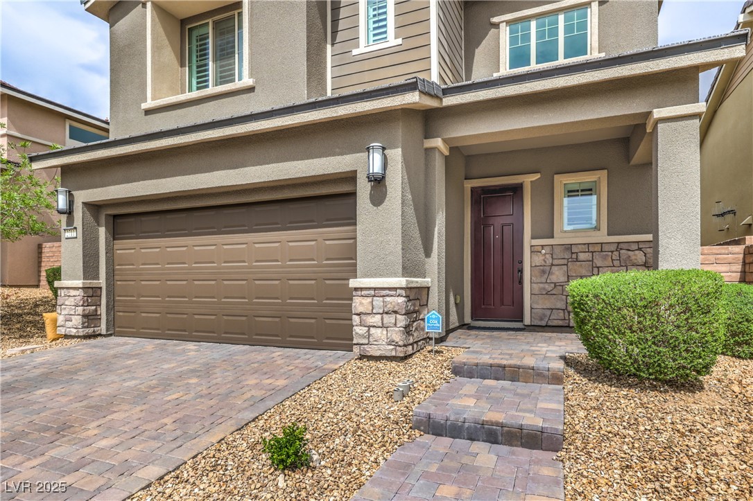 2711 Evolutionary Lane Las Vegas, NV 89138 - Photo 3 of 37 View of exterior entry with stone siding, stucco siding, and a garage