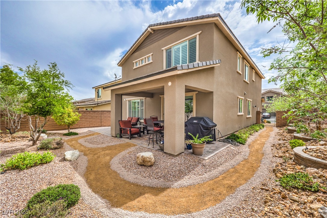2711 Evolutionary Lane Las Vegas, NV 89138 - Photo 36 of 37 Back of property featuring stucco siding, a patio, and a fenced backyard