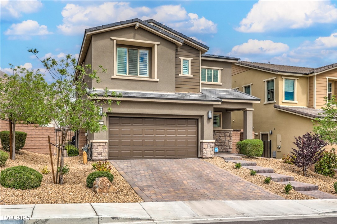 2711 Evolutionary Lane Las Vegas, NV 89138 - Photo 4 of 37 View of front of home with stone siding, stucco siding, a garage, and decorative driveway