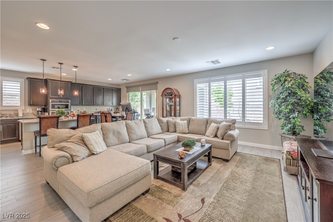 2711 Evolutionary Lane Las Vegas, NV 89138 - Photo 6 of 37 Living room featuring recessed lighting, plenty of natural light, light wood-type flooring, and baseboards