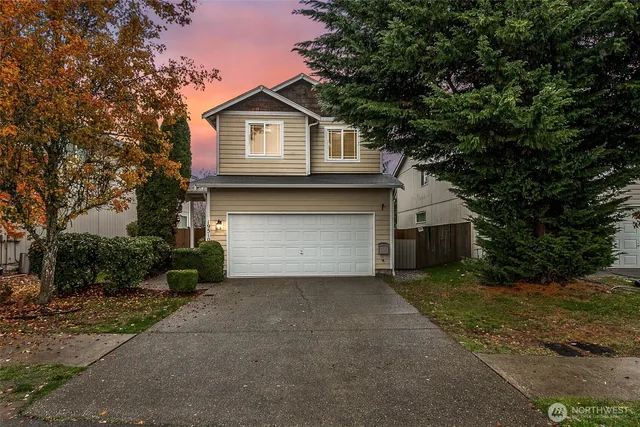 a front view of a house with a yard and garage