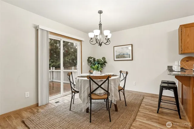 a view of a dining room with furniture a chandelier and wooden floor