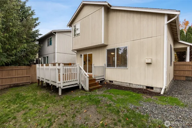a backyard of a house with a small yard and wooden fence