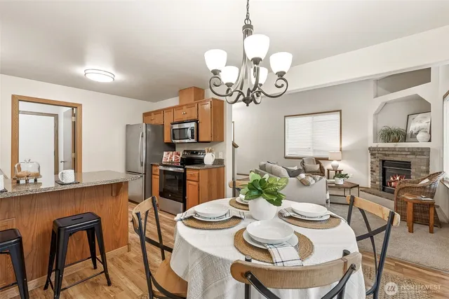 a dining room with wooden floor a chandelier a wooden table and chairs
