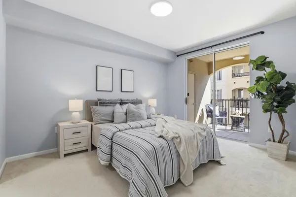 a bedroom with a large bed and a potted plant