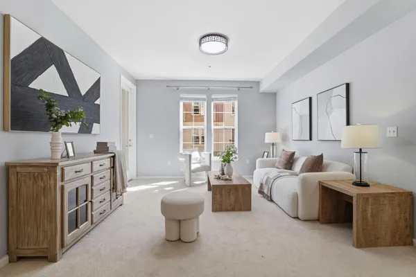 a living room with furniture fireplace and a large window