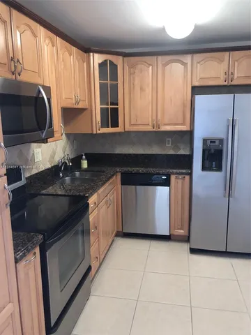 a kitchen with a stove a sink and a microwave