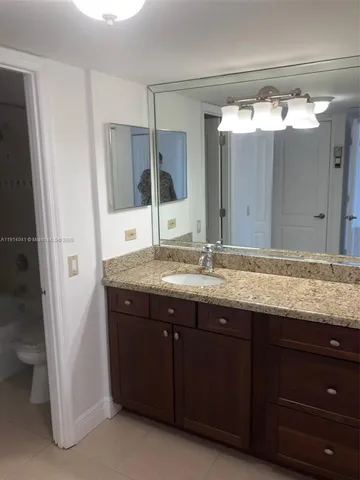 a bathroom with a granite countertop sink and a mirror