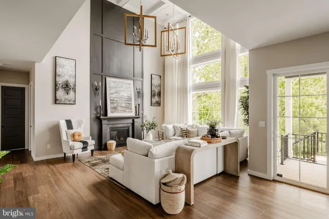 a living room with furniture floor to ceiling window and wooden floor