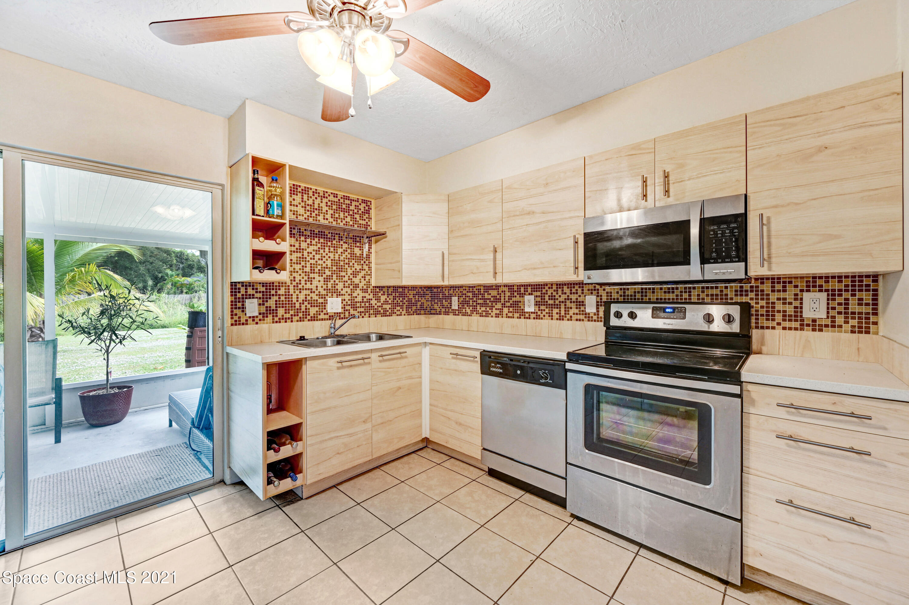 1537 Magnolia Street Northeast Palm Bay, FL 32905 - Photo 15 of 29 a kitchen with stainless steel appliances white cabinets a stove top oven and sink