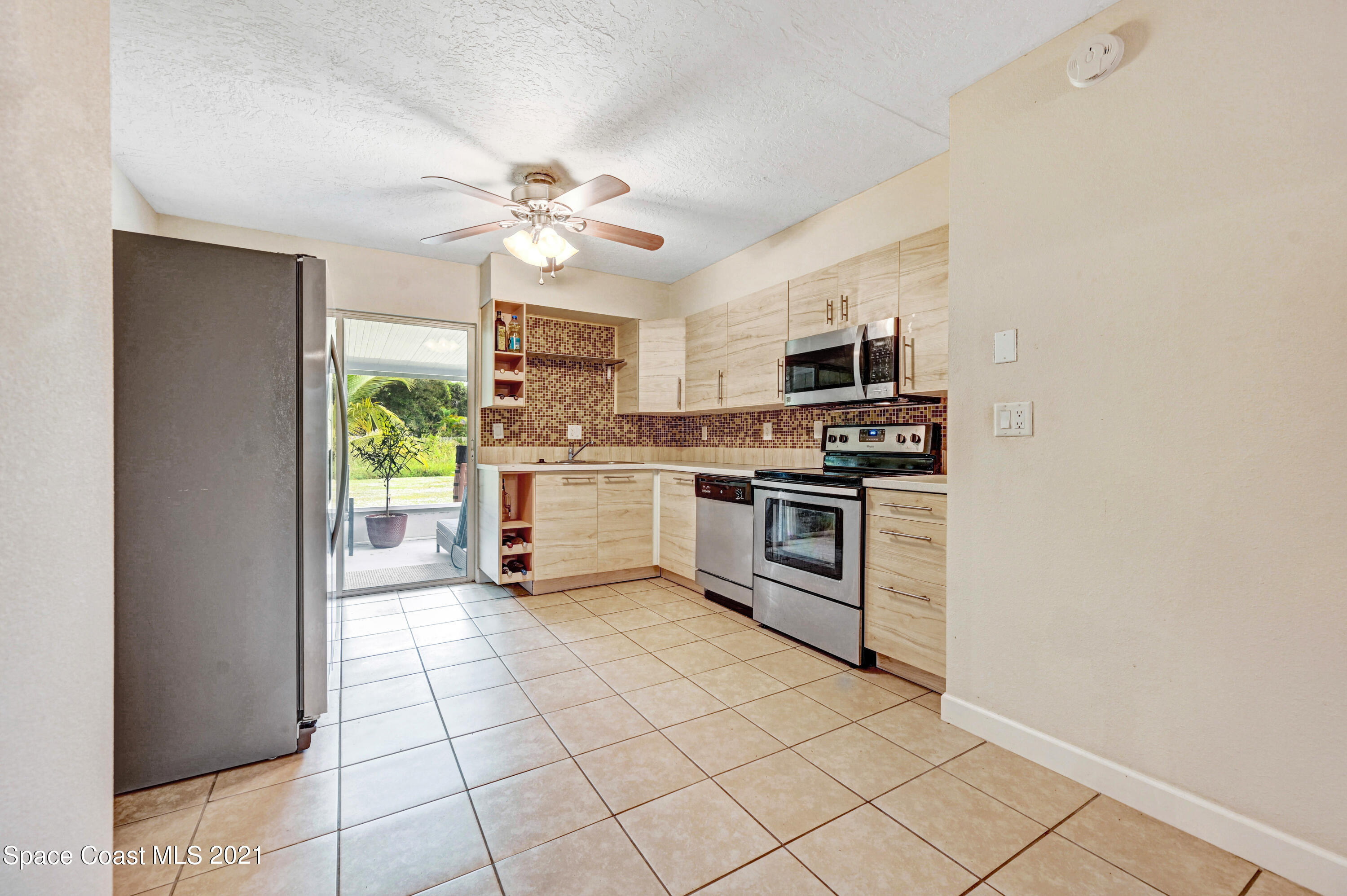 1537 Magnolia Street Northeast Palm Bay, FL 32905 - Photo 18 of 29 a kitchen with cabinets stainless steel appliances and a window