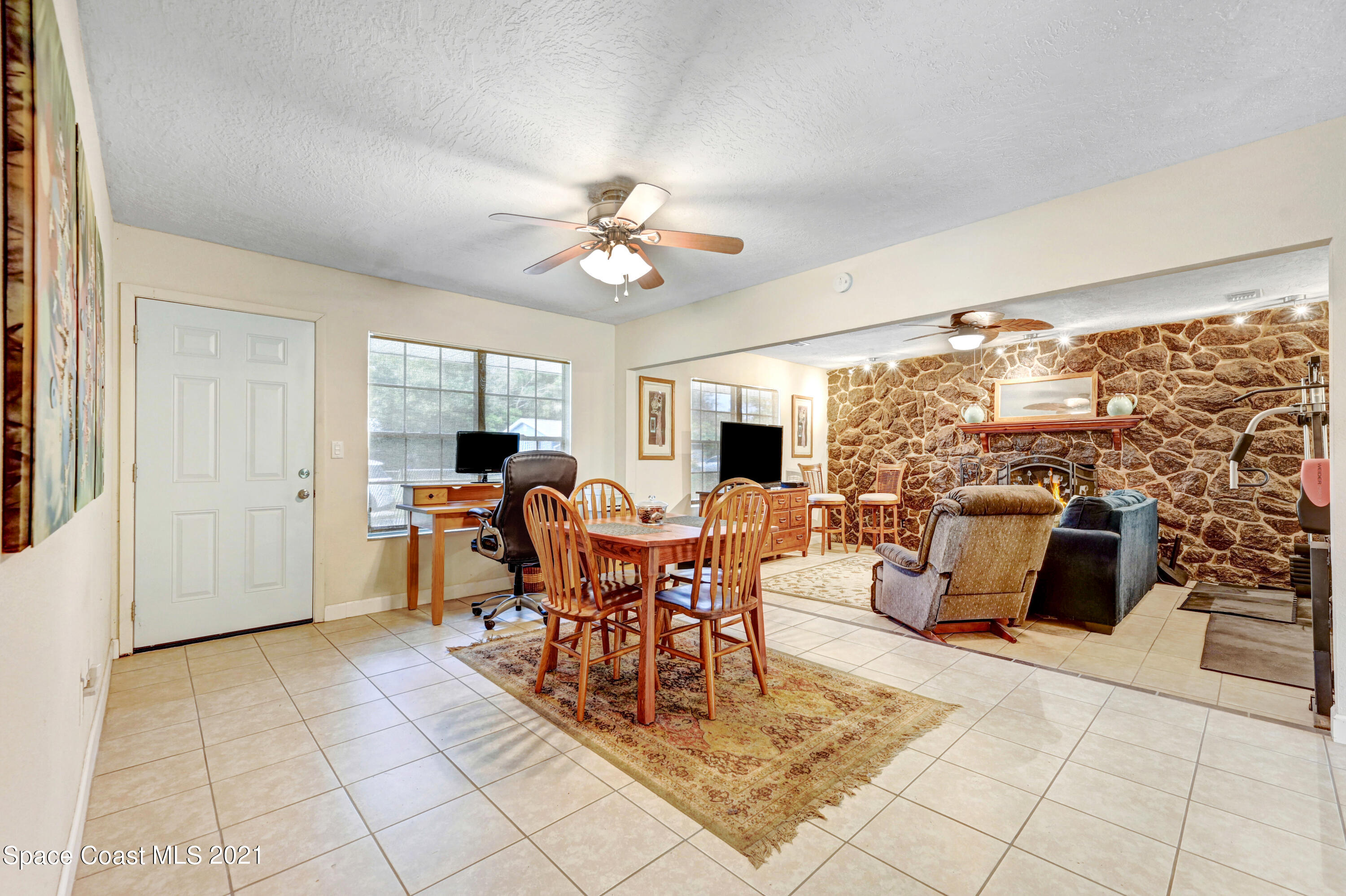 1537 Magnolia Street Northeast Palm Bay, FL 32905 - Photo 21 of 29 a living room with furniture a dining table and a floor to ceiling window