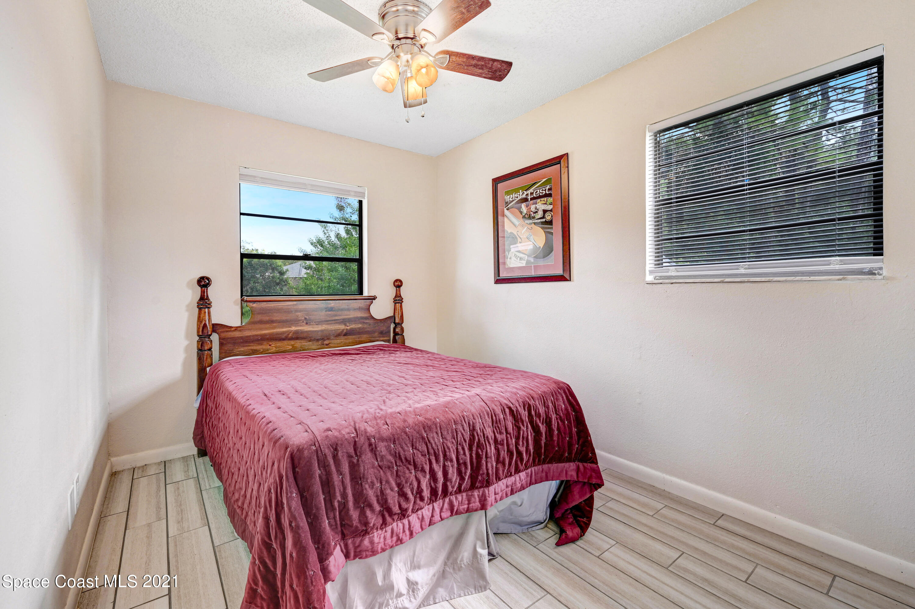 1537 Magnolia Street Northeast Palm Bay, FL 32905 - Photo 28 of 29 a bedroom with a bed and a chandelier