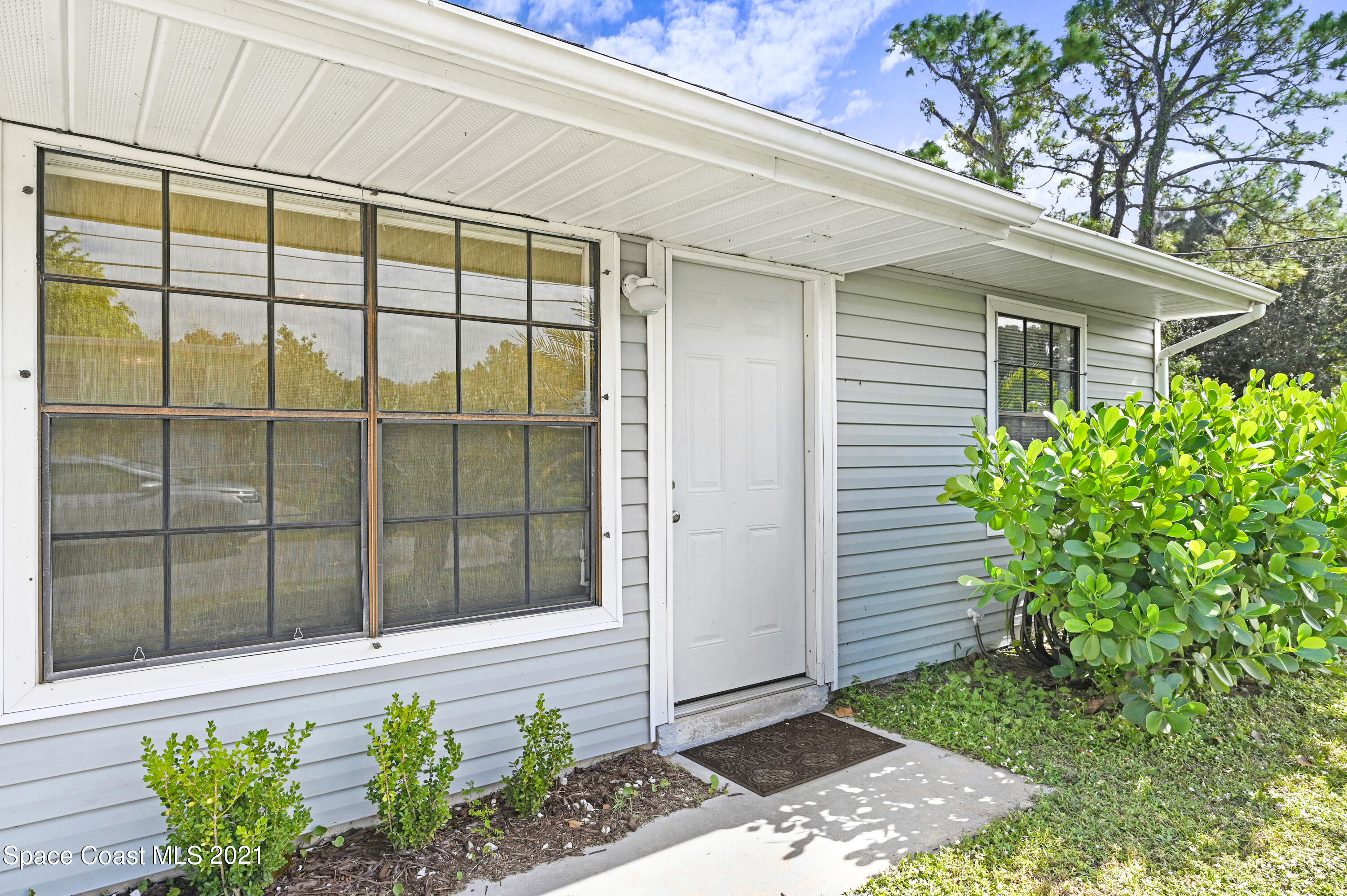 1537 Magnolia Street Northeast Palm Bay, FL 32905 - Photo 3 of 29 a front view of a house with a garden