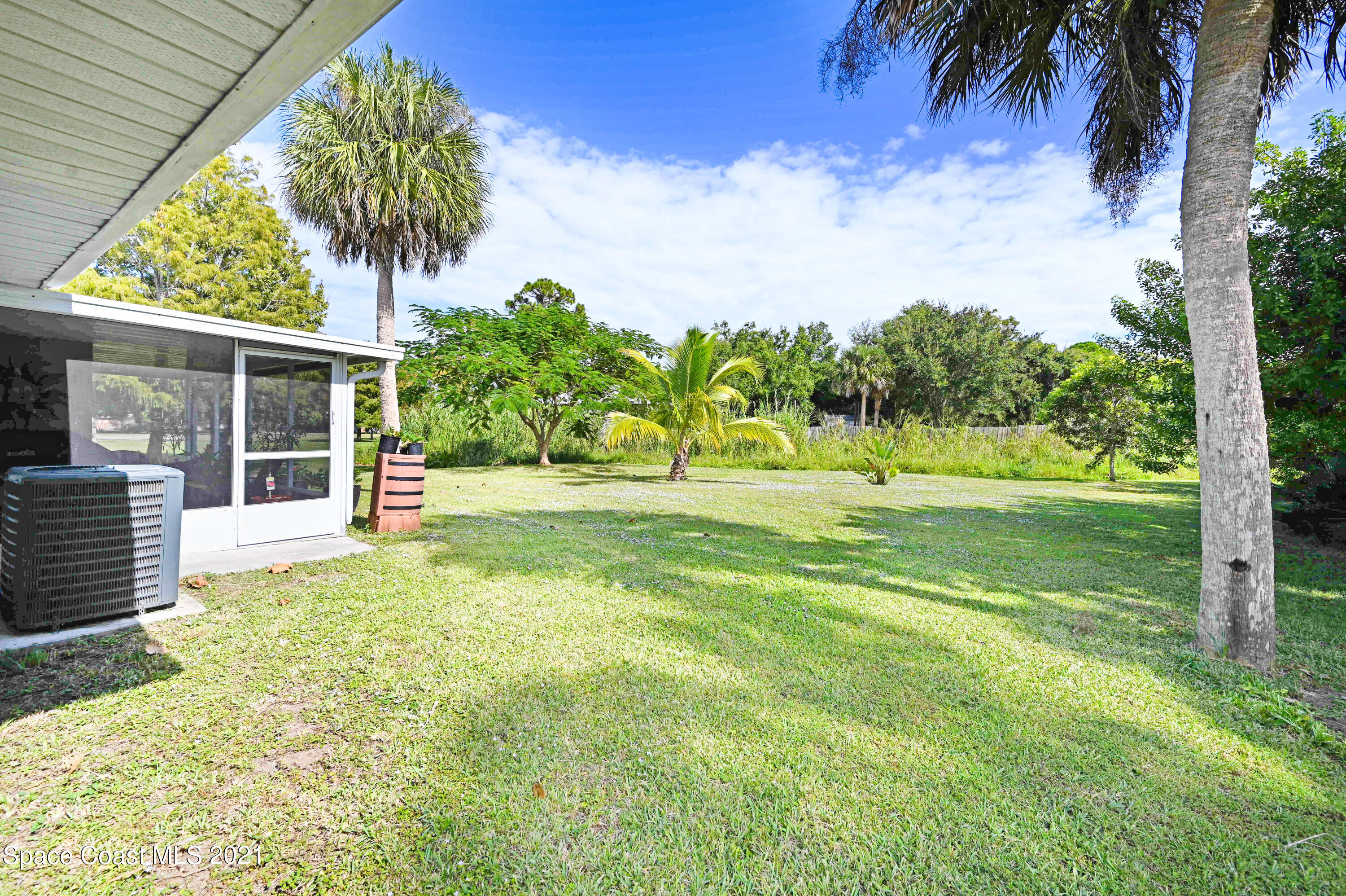 1537 Magnolia Street Northeast Palm Bay, FL 32905 - Photo 8 of 29 a view of a house with a big yard and potted plants