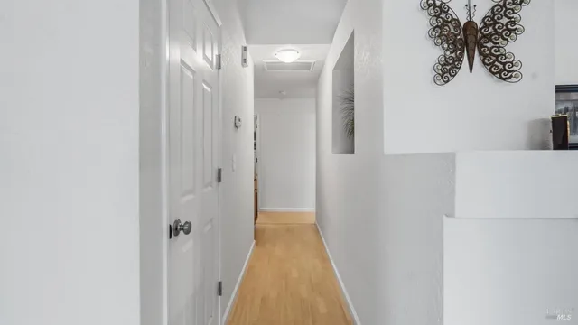 a view of a hallway with wooden floor