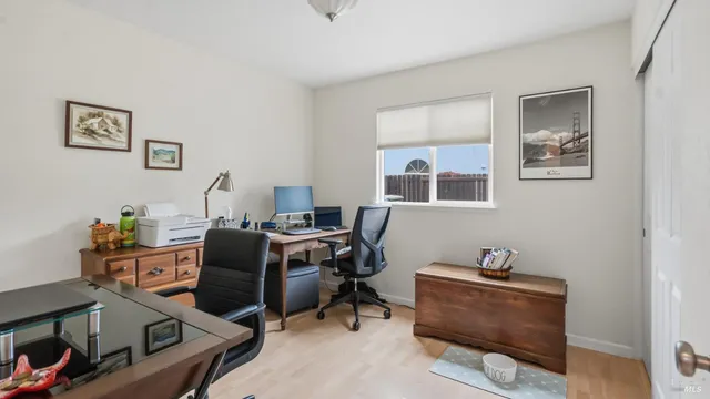 a view of a workspace with furniture and a window