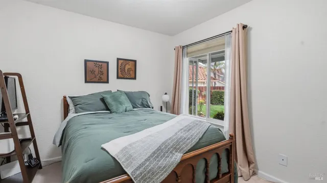 a bed sitting in a bedroom next to a window