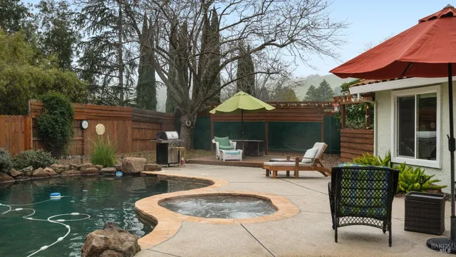 a view of a house with backyard water fountain and sitting area