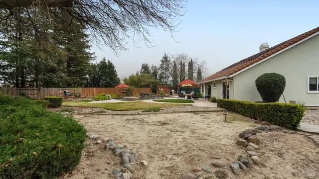 a view of a patio with couches and table and chairs under an umbrella