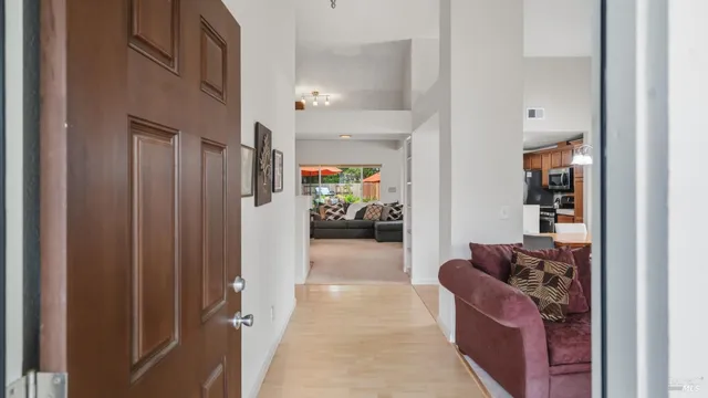 a living room with furniture and a hallway