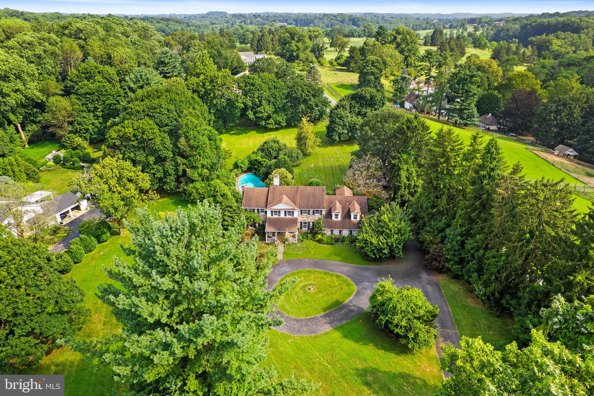 an aerial view of residential houses with outdoor space and trees all around