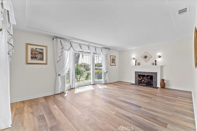 a view of an empty room with window and fire place