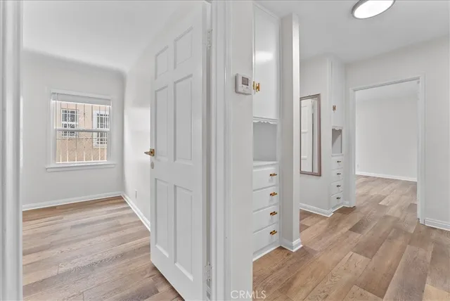a view of empty room with cabinet and window