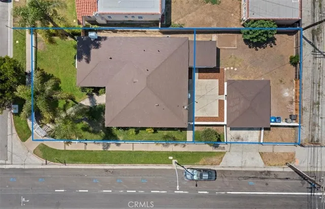 an aerial view of a house with a yard and a large tree