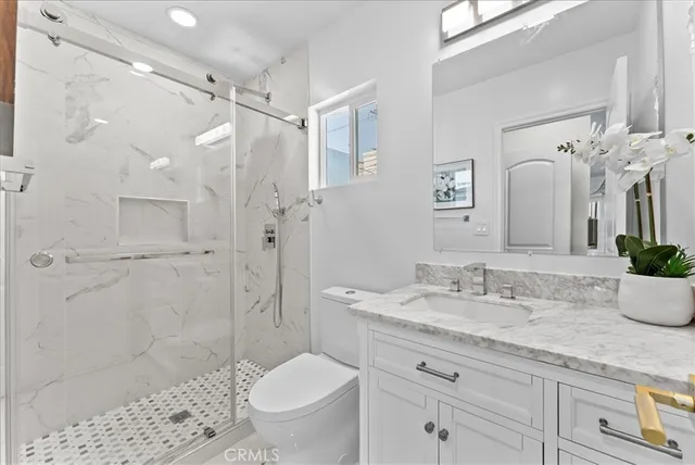 a bathroom with a granite countertop sink toilet and shower
