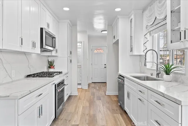 a kitchen with stainless steel appliances granite countertop a sink stove and refrigerator