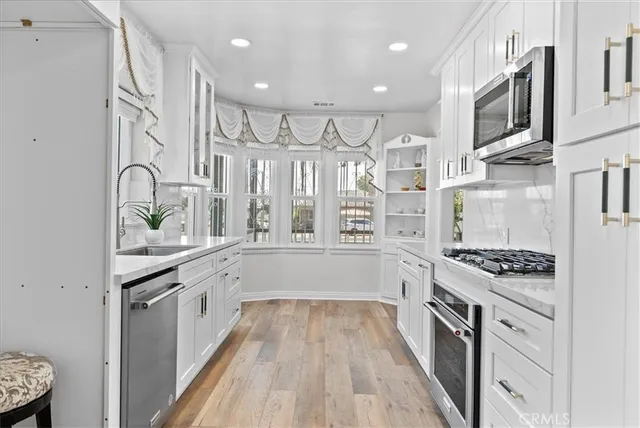 a kitchen with stainless steel appliances a sink stove and cabinets