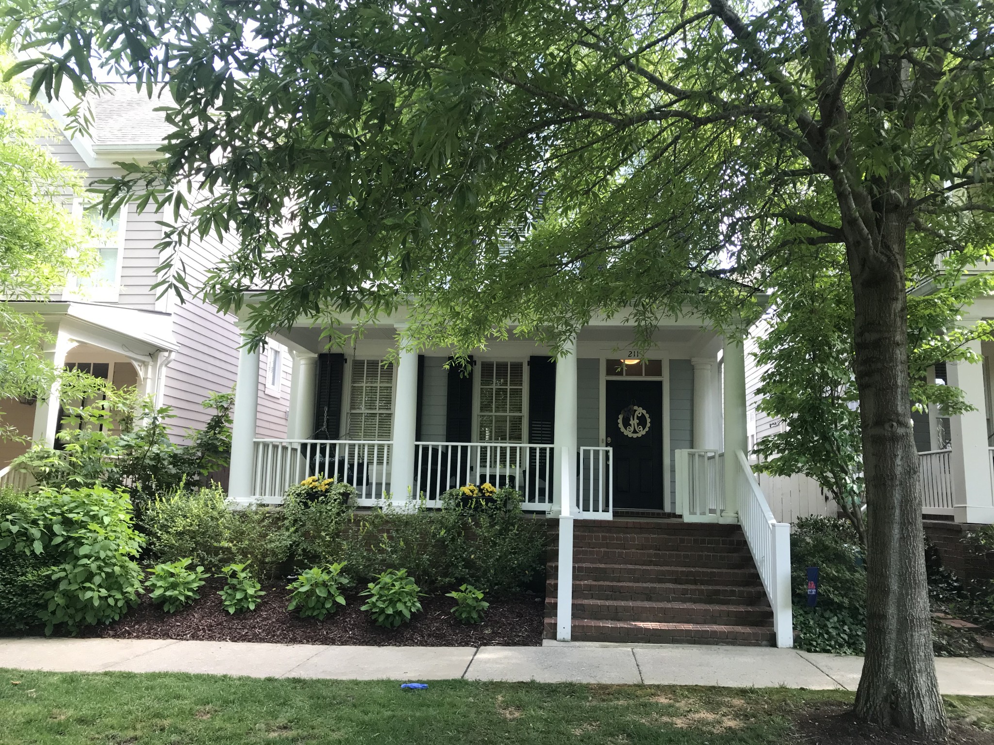 211 Acadia Avenue Franklin, TN 37064 - Photo 2 of 21 a front view of a house with a garden