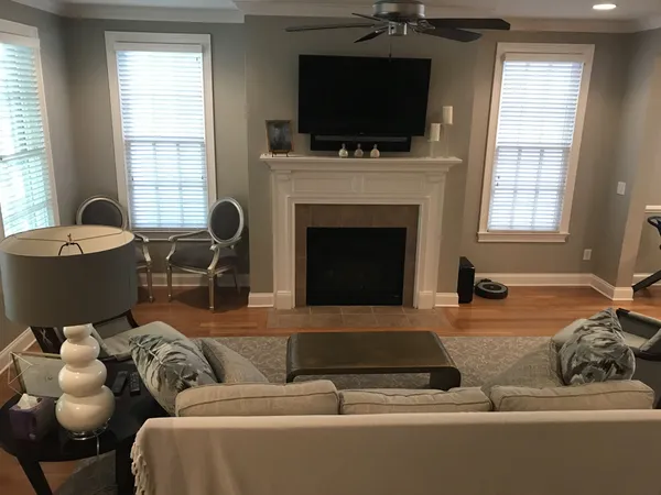 a living room with furniture a flat screen tv and a fireplace