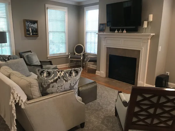a living room with furniture a flat screen tv and a fireplace