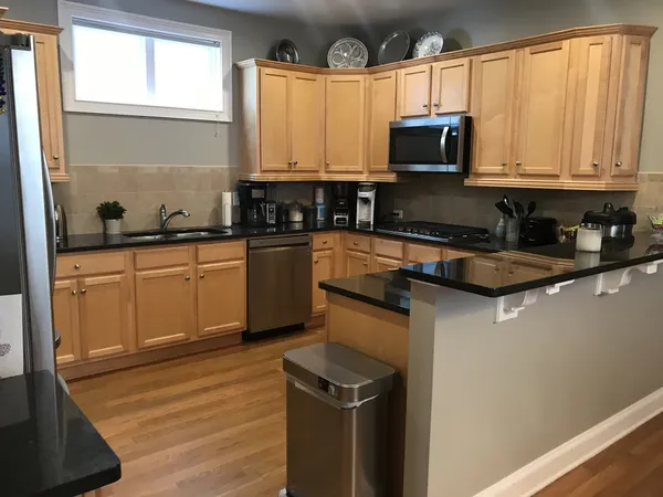 a kitchen with stainless steel appliances granite countertop a stove a sink and a microwave