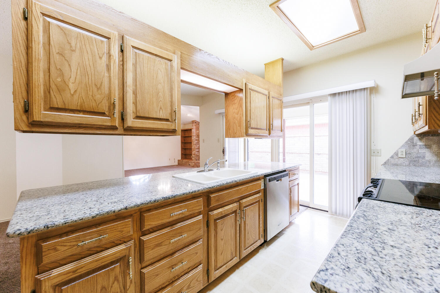 7610 Utica Avenue Lubbock, TX 79424 - Photo 18 of 49 a kitchen with stainless steel appliances granite countertop a sink a stove cabinets and wooden floor