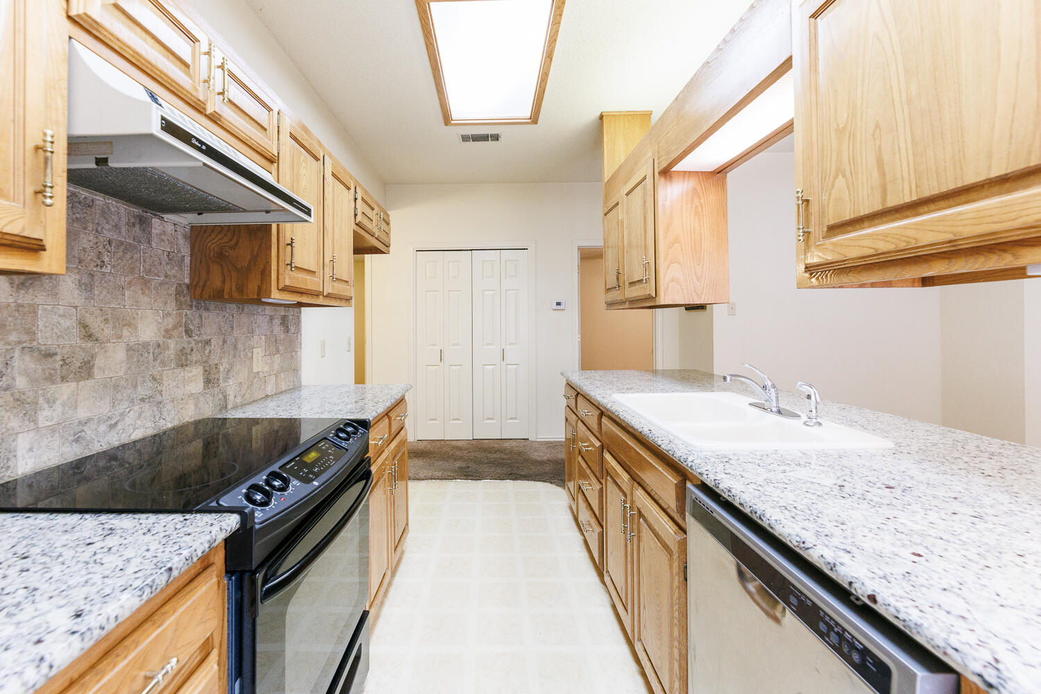 7610 Utica Avenue Lubbock, TX 79424 - Photo 19 of 49 a kitchen with a sink a stove and cabinets