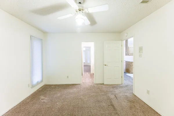 an empty room with fan and entrance