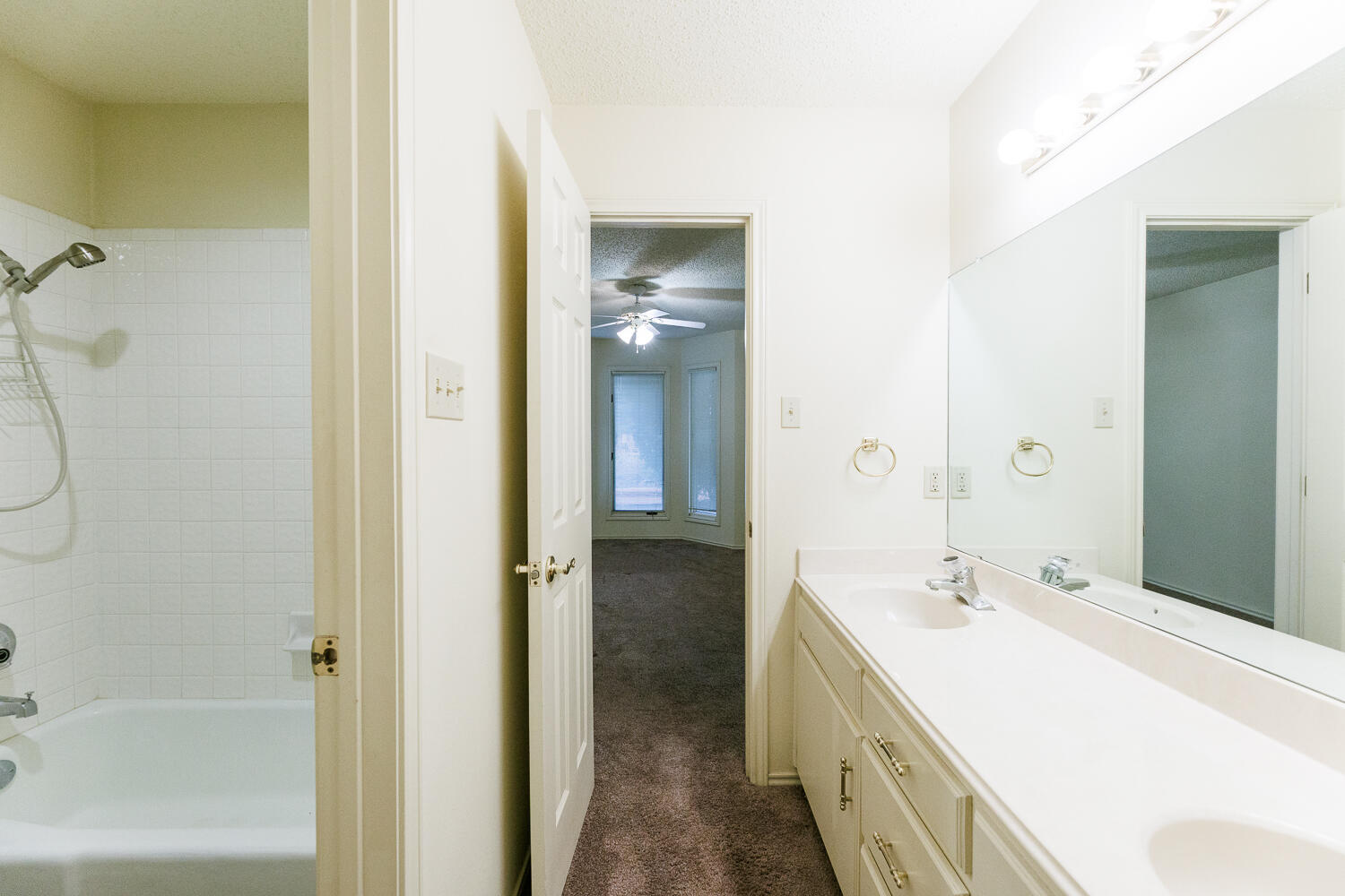 7610 Utica Avenue Lubbock, TX 79424 - Photo 35 of 49 a spacious bathroom with a double vanity sink a mirror and a bathtub