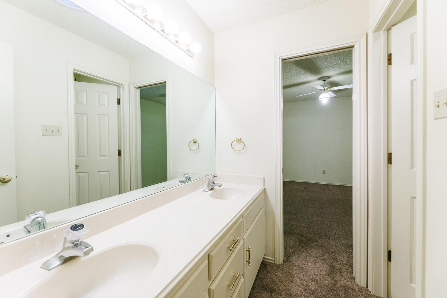7610 Utica Avenue Lubbock, TX 79424 - Photo 38 of 49 a bathroom with a double vanity sink and mirror