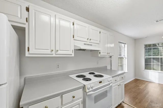 a kitchen with white cabinets and white appliances